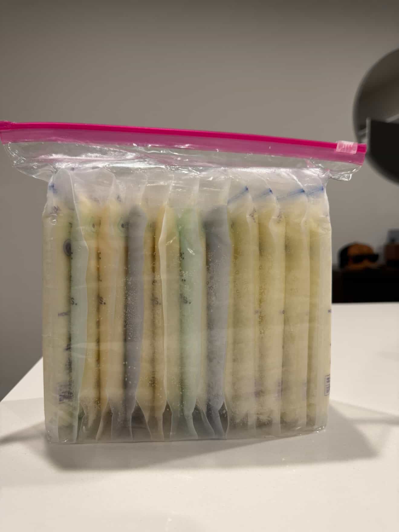 Packaged items in a clear plastic bag with a pink zipper on a white surface.